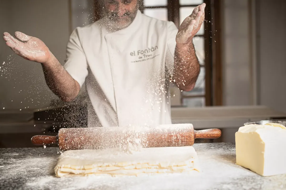 César trabajando una masa con rodillo